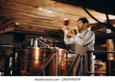 Waist up portrait of bearded brewmaster holding beer glass while inspecting quality of production at brewing factory, copy space - Powered by Shutterstock