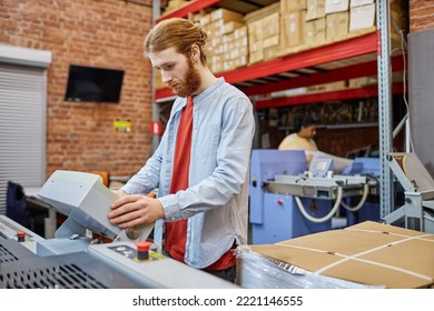 Waist Up Portrait Of Bearded Young Man Setting Up Printing Machine In Workshop, Copy Space