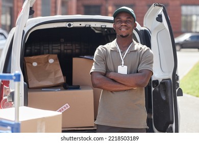 Waist Up Portrait Of Black Young Man As Delivery Man Standing With Arms Crossed By Van In Sunlight, Copy Space