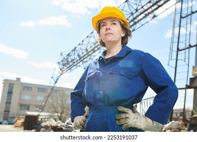 Waist up portrait of empowered woman working at construction site standing against sky with tower crane in background, copy space - Powered by Shutterstock