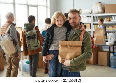 Waist Up Portrait Of Father And Son Holding Food Donations At Volunteer Center For Refugees And People In Need, Copy Space