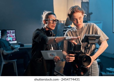 Waist up portrait of female director giving instructions working in video production and operating cameras copy space