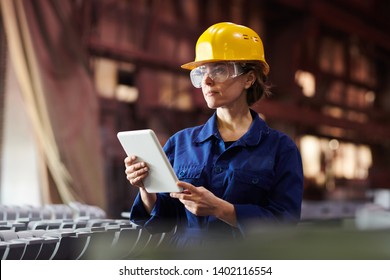 Waist up portrait of female worker using digital tablet while supervising production at plant, copy space - Powered by Shutterstock