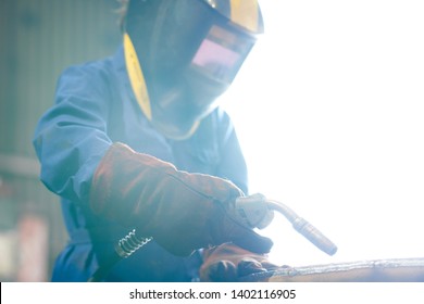 Waist up portrait of female worker welding metal at factory wearing full protective gear and mask, copy space - Powered by Shutterstock