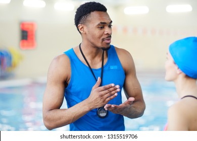 Waist Up Portrait Of Handsome African-American Fitness Coach Talking To Client In Swimming Pool, Copy Space