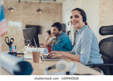 Waist portrait of happy lady sitting in call center while using headset and talking with smile - Shutterstock ID 1439443028