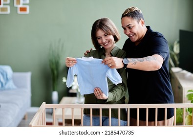 Waist Up Portrait Of Happy Lesbian Couple Expecting Baby And Preparing Crib With Baby Clothes At Home, Same Sex Family, Copy Space