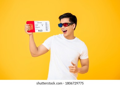 Waist Up Portrait Of Joyful Young Asian Man Wearing 3D Glasses Holding Movie Ticket In Isolated Studio Yellow Background