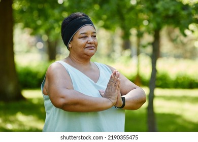 Waist Up Portrait Of Mature Black Woman Doing Yoga Outdoors In Green Park And Looking Away With Mindfulness, Copy Space