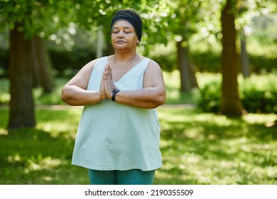 Waist Up Portrait Of Mature Black Woman Doing Yoga Outdoors In Green Park And Holding Hands Together In Prayer Position, Copy Space