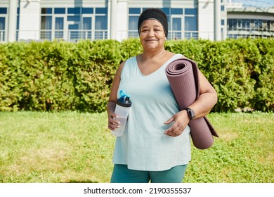 Waist Up Portrait Of Mature Black Woman Holding Yoga Mat Outdoors And Smiling At Camera, Copy Space