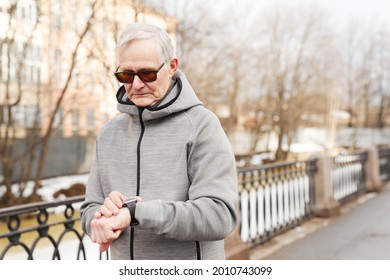 Waist up portrait of modern senior man checking smartwatch while running outdoors in winter, copy space - Powered by Shutterstock