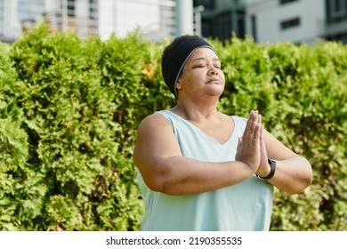 Waist Up Portrait Of Overweight Mature Woman Holding Hands Together And Medtating Outdoors, Copy Space