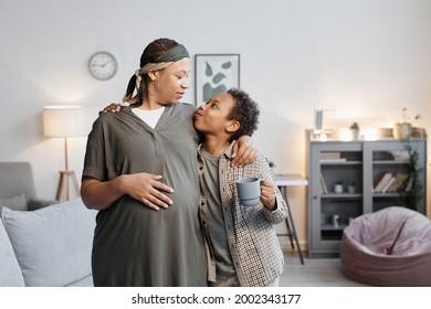 Waist Up Portrait Of Pregnant African-American Woman Embracing Teenage Son While Standing At Home, Happy Two Children Family, Copy Space