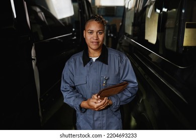 Waist Up Portrait Of Smiling Female Worker Looking At Camera While Standing In Car Factory Workshop