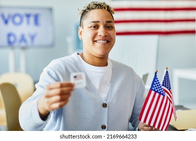 Waist Up Portrait Of Smiling Person Holding Voting Sticker And American Flag On Election Day