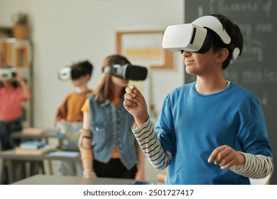 Waist up portrait of smiling young boy wearing VR headset in school enjoying mixed reality simulation with group of children in class copy space - Powered by Shutterstock