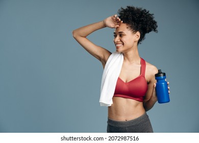 Waist Up Portrait Of Sweaty And Tired Athletic Woman Having Rest After Intensive Working Out. She Is Relaxing With Bottle Of Cool Drink