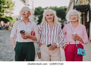 Waist Up Portrait Of Three Beautiful Older Women Having Fun Together While Holding Coffee