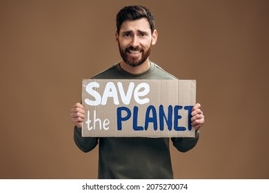 Waist Up Portrait View Of The Caucasian Worried Man Holding Carton Placard With Save The Planet Writing. Concept Of Nature Destruction And Eco Activism