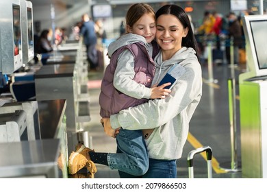 Waist Up Portrait View Of The Overjoyed Mother And Daughter Embracing With Each Other After Giving Documents To Airport Worker 
