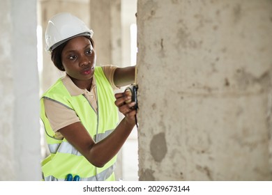 Waist up portrait of young African-American woman working at construction site in engineering, copy space