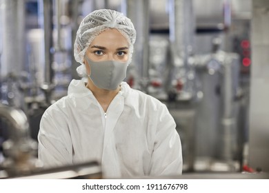 Waist Up Portrait Of Young Female Worker Wearing Mask And Looking At Camera While Working At Food Factory, Copy Space