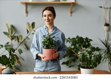 Waist up portrait of young woman posing with lush greenery at home and holding potted plant, looking at camera - Powered by Shutterstock