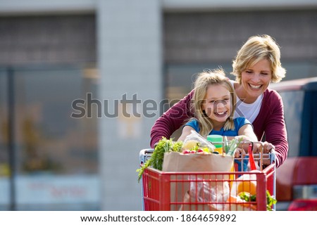 Similar – Image, Stock Photo Mother pushing shopping cart with her infant baby boy child down department aisle in supermarket grocery store. Shopping with kids concept.