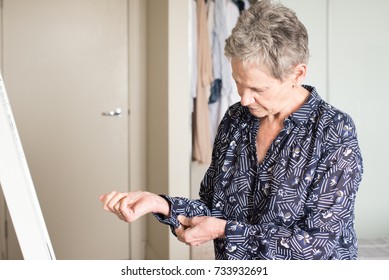 Waist Up View Of Older Woman Doing Buttons On Blouse While Getting Dressed In Bedroom (selective Focus)