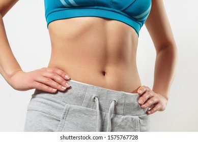 waist of a young woman with a slim figure in sportswear. on white background