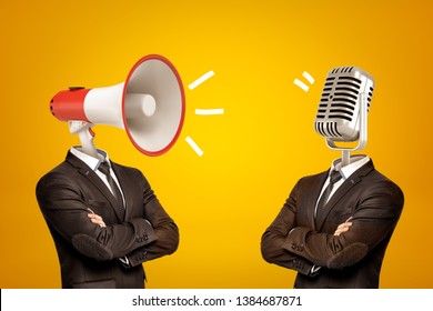 Waist-deep view of two businessmen standing in half-turn, arms folded, with megaphone and microphone instead of heads. Opinion leaders. Media influence public opinion. Media and people.