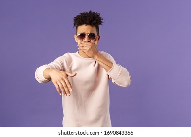 Waist-up portrait of cool and sassy, young carefree guy with dreads and sunglasses, cover mouth to beatbox, waving hand in rhythm music, singing rap or attend hip-hop party, purple background