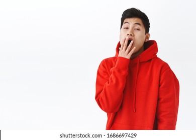 Waist-up Portrait Of Sleepy Bored Hipster Guy, Asian Young Man Yawning And Cover Opened Mouth, Look Camera With Boring Face, Waking Up Early, Need Coffee, Standing White Background