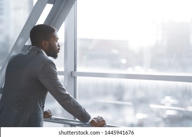 Wait For Flight. Afro Businessman Looking Through Window In Airport