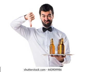 Waiter With Beer Bottles On The Tray Doing Bad Signal