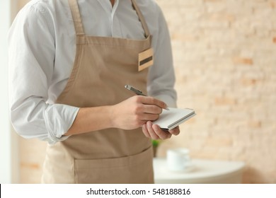 Waiter In Beige Apron Writing Down An Order In A Cafe, Close Up