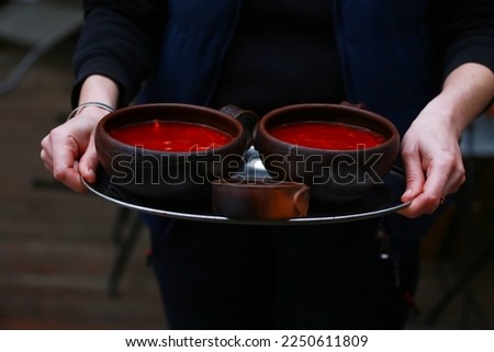 the waiter carries a bowl of soup