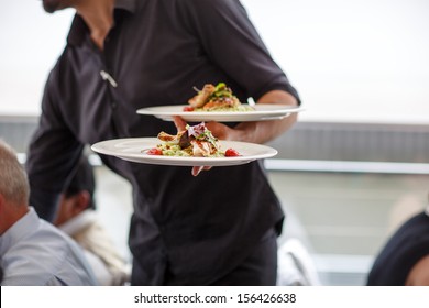 Waiter carrying a plate with salad dish on a wedding