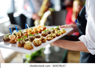 Waiter carrying plates with meat dish on some festive event, party or wedding reception - Shutterstock ID 333578117