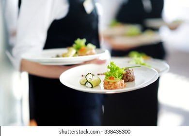 Waiter carrying plates with meat dish on some festive event, party or wedding reception - Powered by Shutterstock