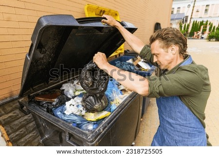Waiter, chef, or kitchen worker responsibly throwing out garbage into trash can in back yard. Importance of waste management and cleanliness in service industry, particularly in restaurants and