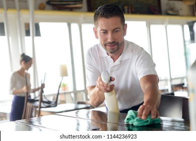 Waiter Cleaning Countertop With Sponge