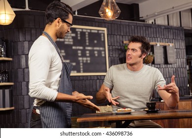 Waiter and customer having a discussion in a coffee shop - Powered by Shutterstock