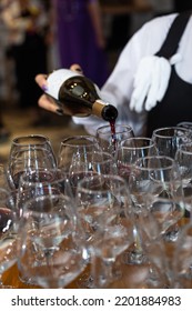 The Waiter Girl Pours Red Wine Into Glasses.