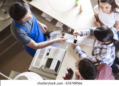 Waiter Giving Receipt To Woman With Family At Icecream Parlor - Powered by Shutterstock