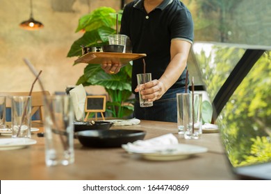 Waiter Hand Pick Up Empty Glasses And Dirty Dishes On Dinner Restaurant.