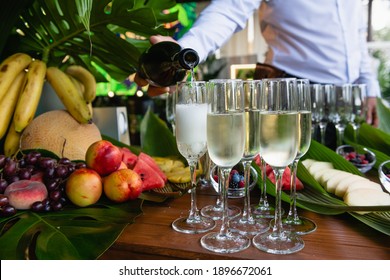 Waiter Hands Pour Chilled Champagne In Glasses