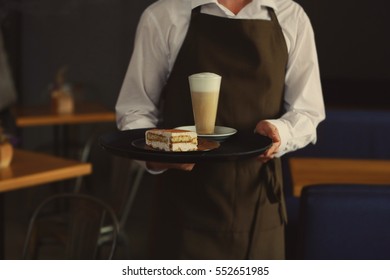 Waiter holding tray with tasty dessert and chocolate drink, close up view - Powered by Shutterstock