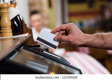 Waiter Inserts The Card Into A Computer Terminal, Against Visiting The Restaurant